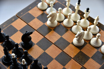 An old chessboard with white and black pieces