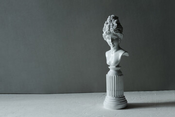 Red lipstick on a light textured background, plaster figure.Сopy space.