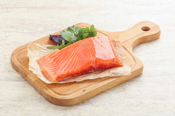 Raw salmon fillet over board