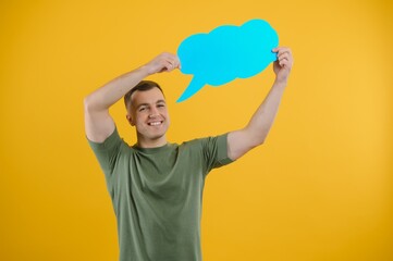 Young caucasian man isolated on yellow background holding a thinking speech bubble and doing OK sign