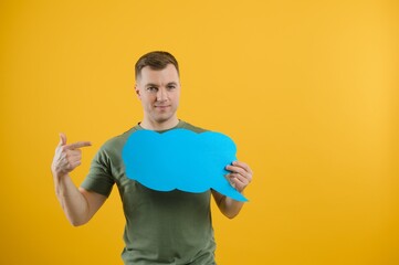 Young caucasian man isolated on yellow background holding a thinking speech bubble and doing OK sign