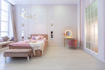 luxurious modern bedroom interior of an expensive spacious light stylish apartment. upholstered furniture and decorative lighting, soft pastel colors and cozy atmosphere