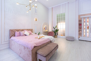 luxurious modern bedroom interior of an expensive spacious light stylish apartment. upholstered furniture and decorative lighting, soft pastel colors and cozy atmosphere