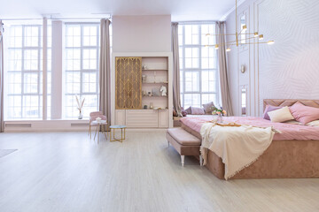 luxurious modern bedroom interior of an expensive spacious light stylish apartment. upholstered furniture and decorative lighting, soft pastel colors and cozy atmosphere