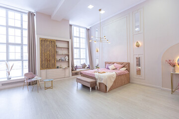 luxurious modern bedroom interior of an expensive spacious light stylish apartment. upholstered furniture and decorative lighting, soft pastel colors and cozy atmosphere