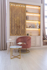 a corner for reading and relaxing in a modern lux trendy expensive apartment with a luxurious decorative stele in gold color