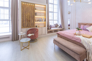 luxurious modern bedroom interior of an expensive spacious light stylish apartment. upholstered furniture and decorative lighting, soft pastel colors and cozy atmosphere