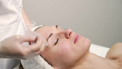 Doctor doing skin routine. Salon maternity treatment. Health care concept. Female person. Pandemic guasha acupunture face massage. Anti age procedure video - Powered by Adobe