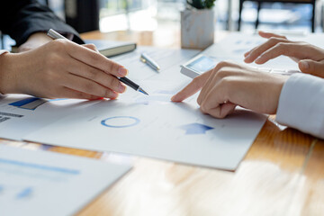 Two businessmen are reviewing the earnings summary and company financial documents that each department produces and submits for monthly audits. Concept of checking company information sheet.