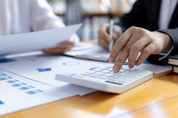 Fototapeta premium Two businessmen are reviewing the earnings summary and company financial documents that each department produces and submits for monthly audits. Concept of checking company information sheet.