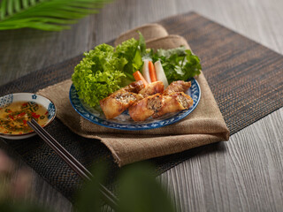 deep fried spring rolls in colorful dish on wooden table