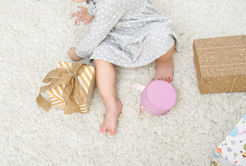 Girl sits on a white carpet among the gifts