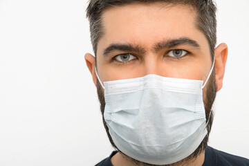 A young man with a beard and masks. Security measures. Masked man. Isolated background.