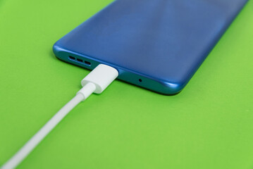 Blue cell phone connected to USB cable type C - Charging