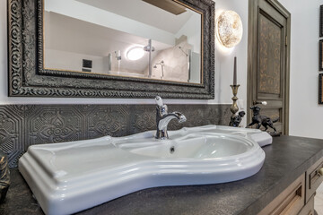 metal water tap with sink and faucet to turn on and regulate cold or hot water in expensive bathroom.