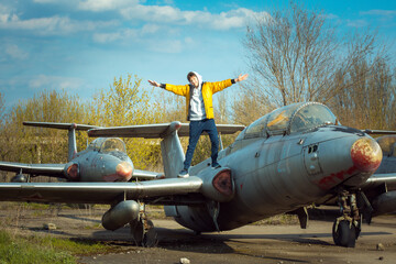A young man in front of an old abandoned Soviet plane. The guy enjoys learning the old technique
