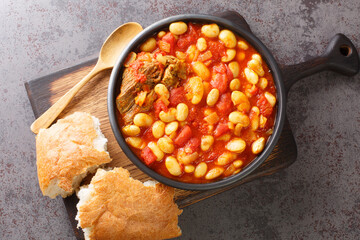 Moroccan loubia is a traditional dish consisting of stewed white beans closeup in the bowl on the...
