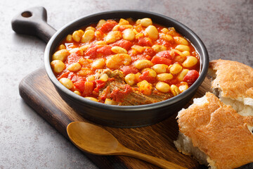 Moroccan loubia is a traditional dish consisting of stewed white beans closeup in the bowl on the...