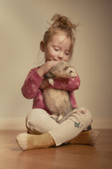 Little girl take care of adult ferret female pet