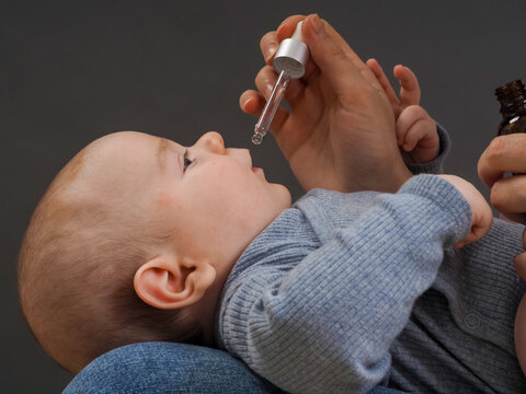 Parent Pipetting Cbd Oil Into Baby's Mouth