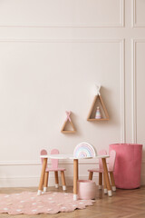 Cute child room interior with furniture, toys and wigwam shaped shelves on white wall