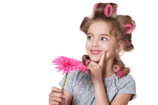 Portrait of little pretty girl with hair curlers posing with flower isolated