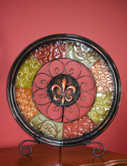 Decorative glass plate in mandala form on wooden table
