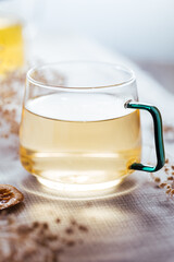 Cup of chamomile tea in transparent mug served with slice of lemon and orange. Tea break. 