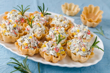Tartlets with crab sticks, eggs, corn, poppy seeds and caviar.