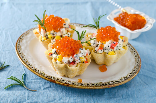 Tartlets with crab sticks, eggs, corn, poppy seeds and caviar.