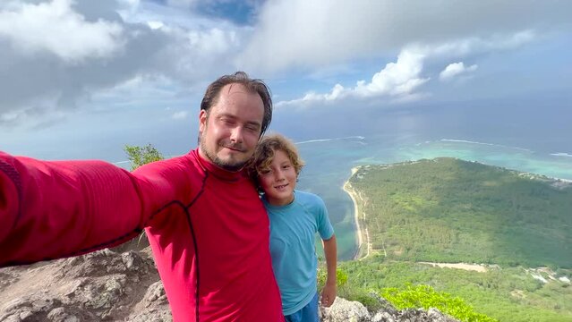 A man and his son take a selfie on Mount Le Morne Mauritius