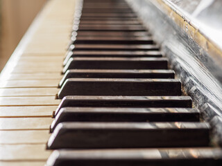 Close side view of shiny black and white old piano keys.
