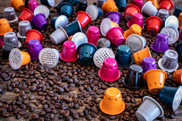 Coffee beans roasted, instant and grinded coffee in the mugs and coffee capsules on the wooden table