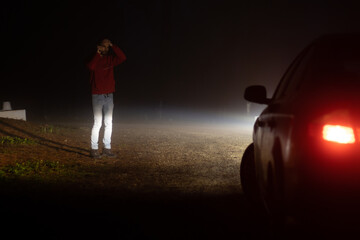 Man calling insurance company outside his broken down car