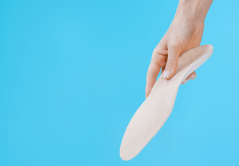 Orthopedic insole isolated on a blue background. Medical insoles. Treatment and prevention of flat feet and foot diseases. Foot care, feet comfort. Wear comfortable shoes. Flat Feet Correction.