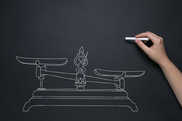 drawing of vintage scales with chalk on a black board, the concept of balance, comparisons, what is more important,