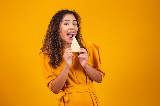 Young Afro Man With A Slice Of Brie Cheese In His Hands. Young Woman Eating Cheese