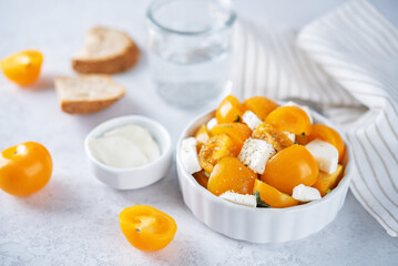 Yellow tomatoes basil pepper mozarella salad in a bowl