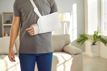 Crop close up of injured man with bandage on broken arm. Pain in hand. Unhealthy guy wear splint sling having elbow or wrist injury have rehabilitation process. Healthcare and rehab concept.