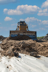 the process of leveling sand with a modern bulldozer during the construction of a dirt road