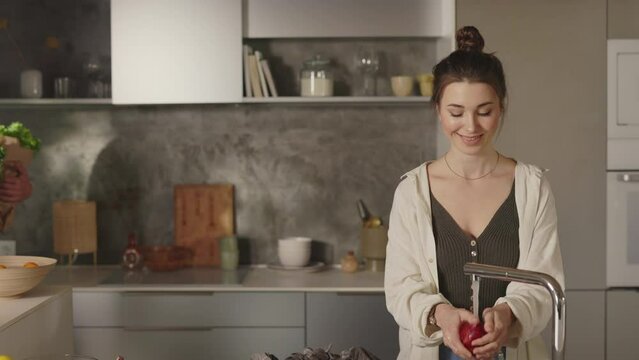 Happy couple staning on kitchen with two grocery bags