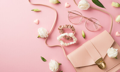 Top view photo of woman's day composition pink leather purse stylish spectacles hearts scrunchies and white prairie gentian flower buds on isolated pastel pink background with blank space