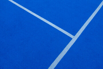 Lines of a blue synthetic grass paddle tennis court