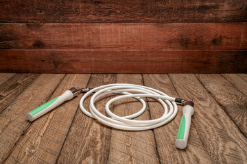 heavy fitness jump rope on rustic, weathered wood background - obrazy, fototapety, plakaty