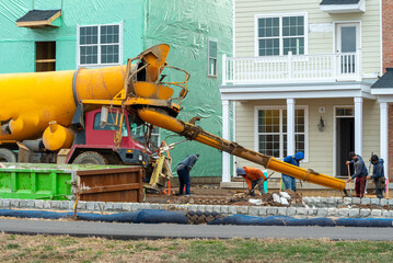 Mixed concrete pouring at construction site pouring cement during sidewalk upgrade pour concrete