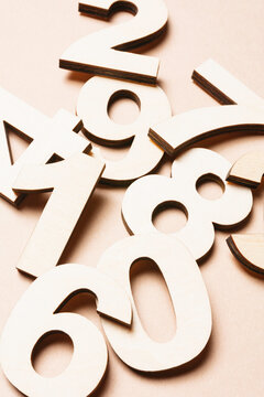 Studio shot of pile of assorted numbers against beige background