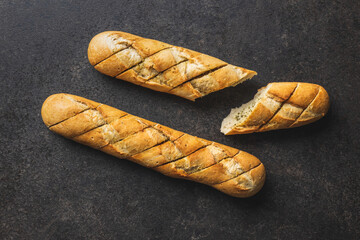 Roasted baguette with garlic butter. Crunchy sliced garlic bread on black table.