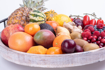 fresh vegetables and fruits isolated on a white background in wooden tray.