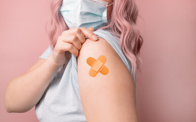 Beautiful young caucasian woman wearing protective mask against covid-19 showing shoulder after...