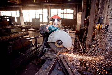 Woman Professional Industry worker with electric wheel grinding on steel structure in factory, light spark
